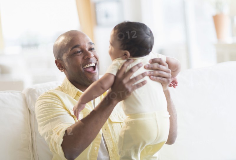 Smiling father playing with baby