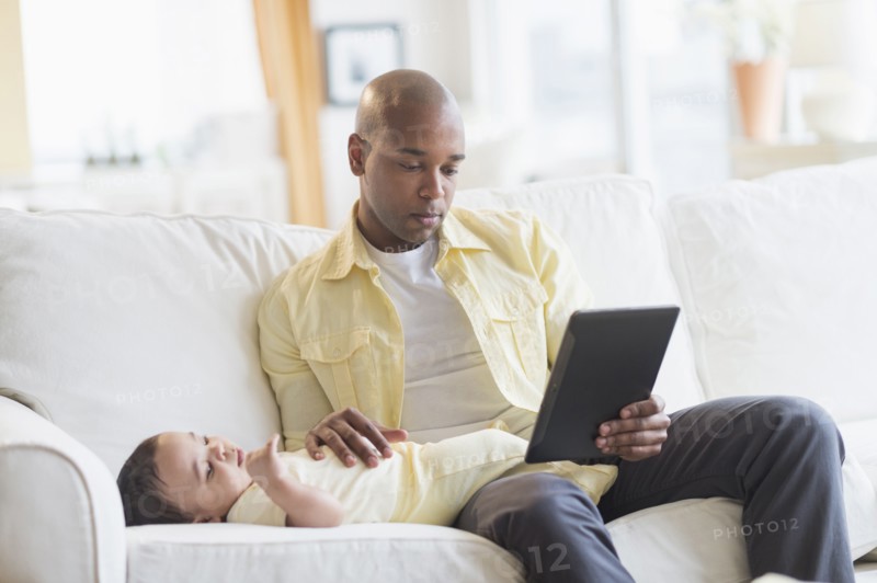 Smiling father relaxing with baby