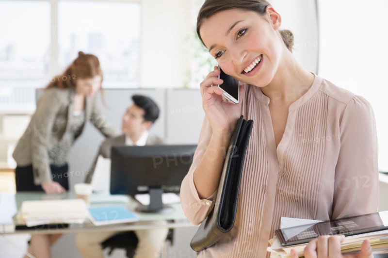 Businesswoman talking on cell phone in office