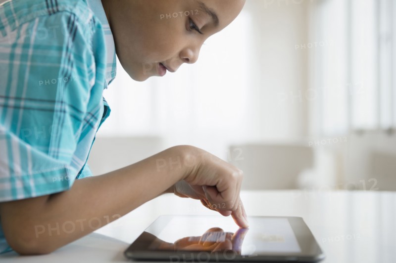 Mixed race boy using tablet computer