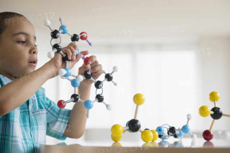 Mixed race boy playing with molecular models