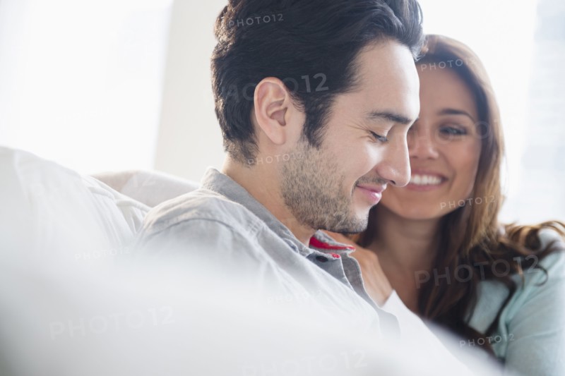 Couple smiling together on sofa