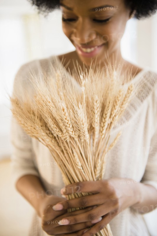 African American woman holding bunch of wheat