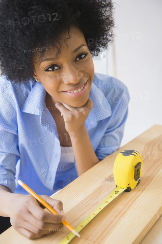 African American woman measuring wood
