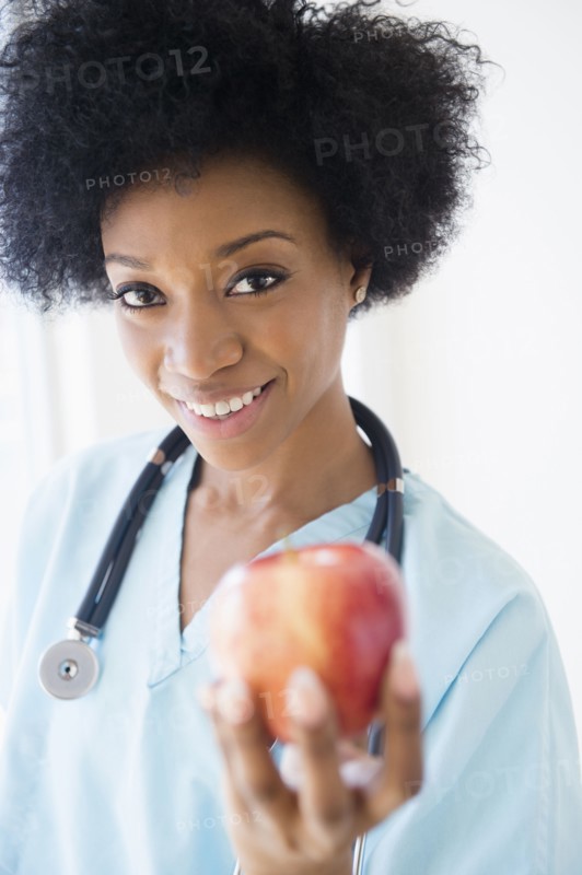 African American nurse holding apple
