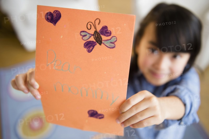 Close up of Filipino girl holding card for mother