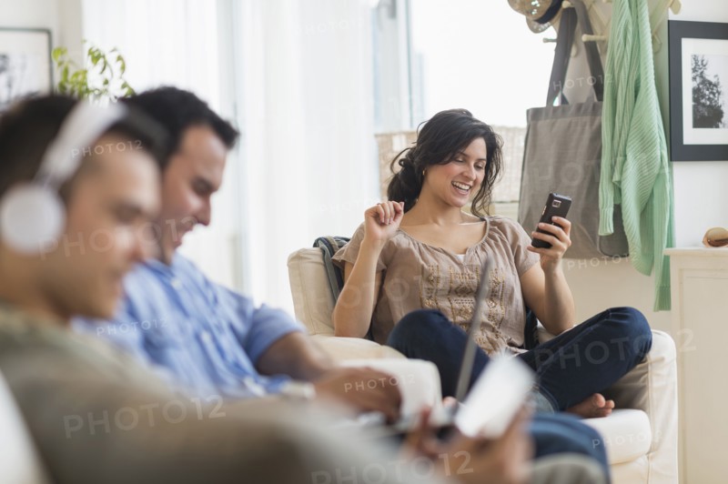 Hispanic friends using technology in living room