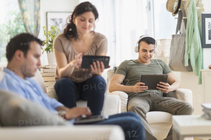 Hispanic friends using technology in living room