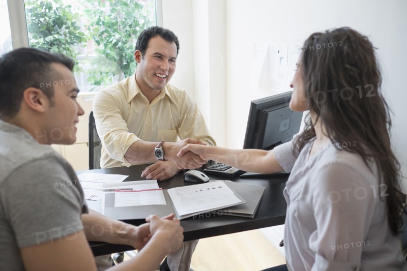 Hispanic businessman shaking hands with client in office