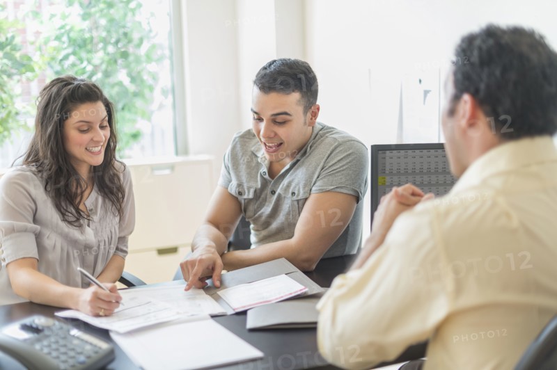 Hispanic businessman talking to clients in office