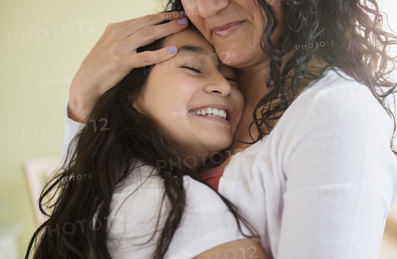 Hispanic mother and daughter hugging