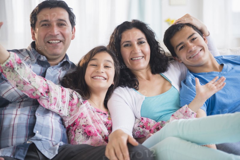 Hispanic family smiling together on sofa