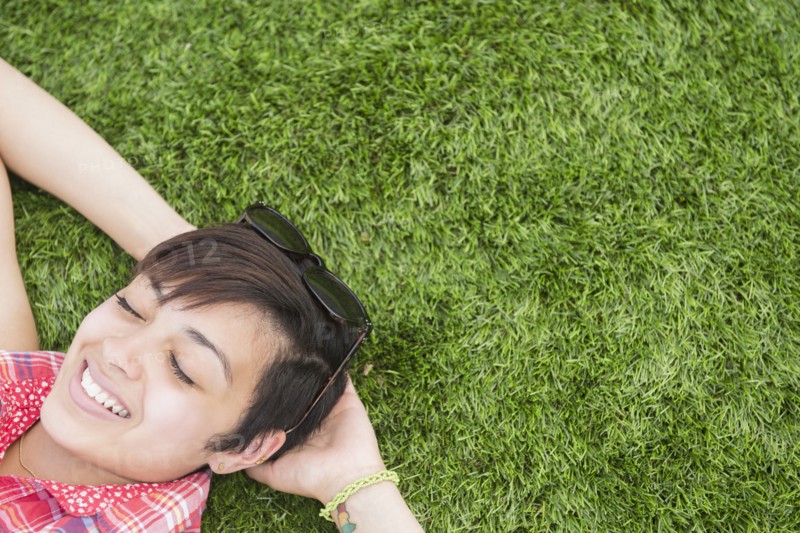 Mixed race woman laying in grass outdoors