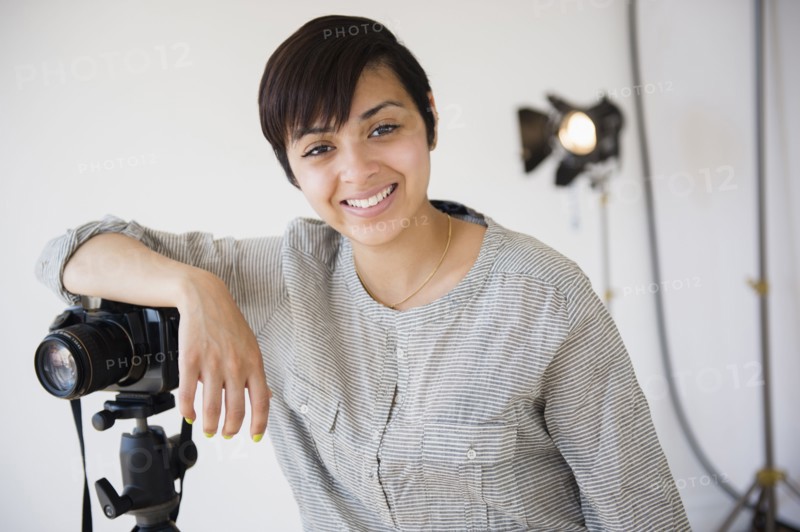 Mixed race photographer smiling in studio