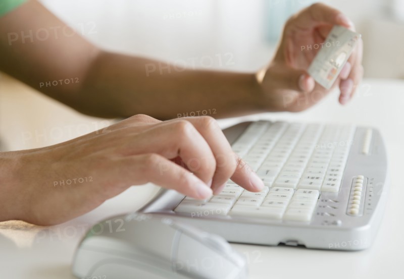 Mixed race man shopping online with credit card