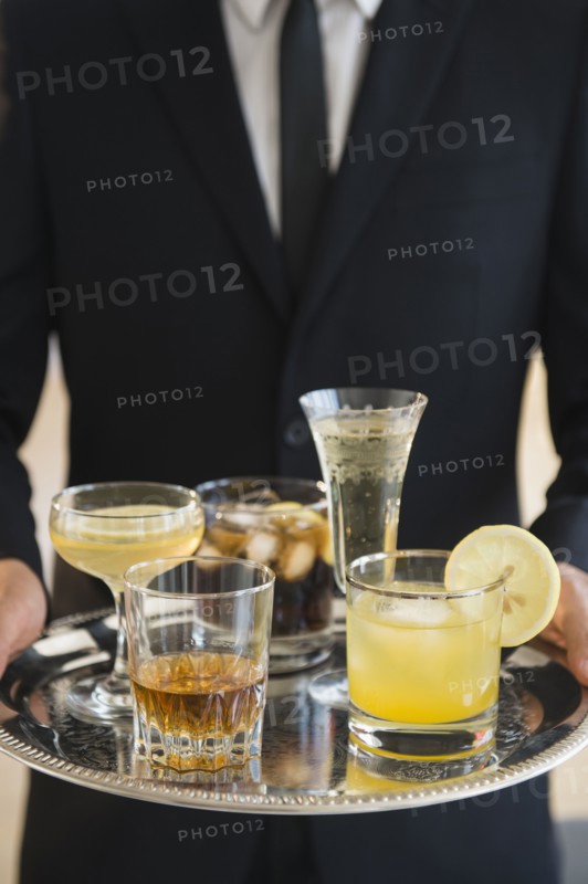 Close up of mixed race waiter holding tray of drinks