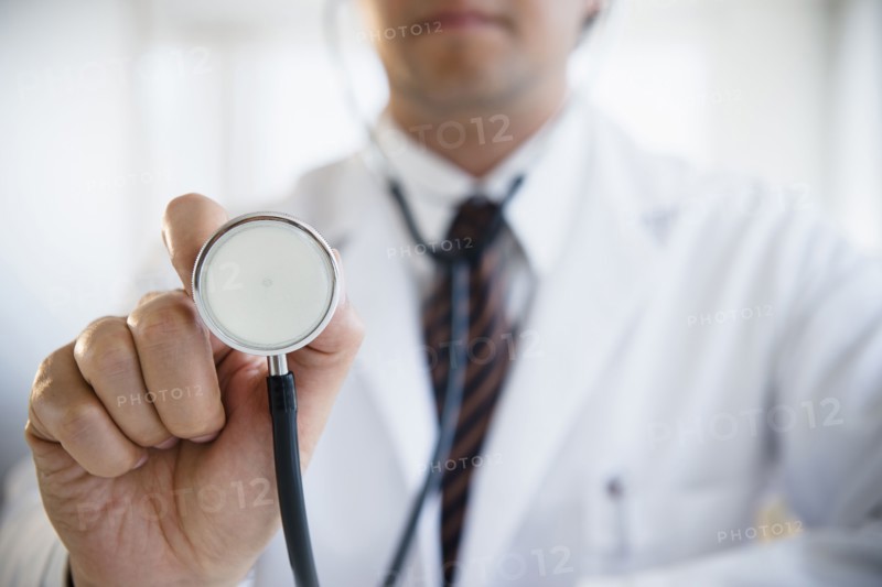 Close up of mixed race doctor holding stethoscope
