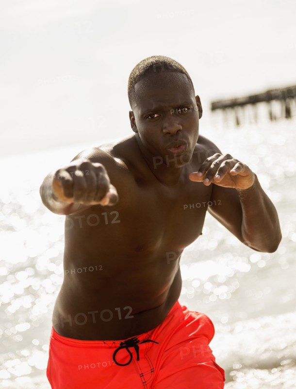Mixed race man training on beach