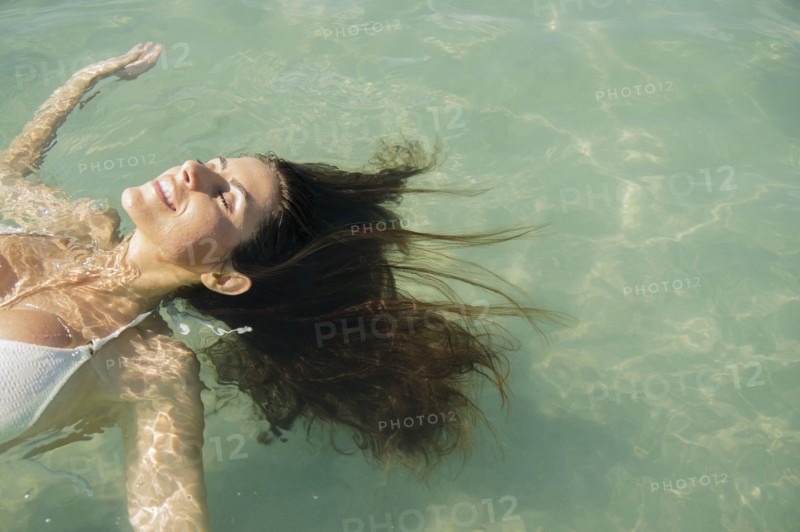 Caucasian woman floating in ocean