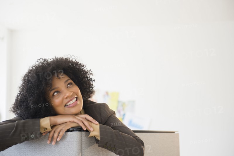 Businesswoman leaning over cubicle wall in office