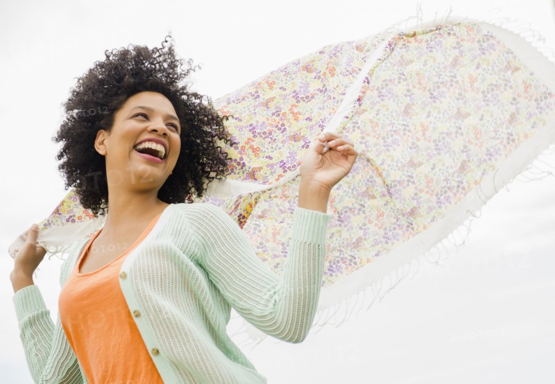 Low angle view of woman playing with scarf outdoors