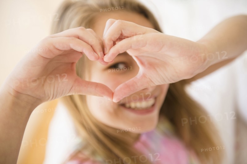 Caucasian girl making heart shape with hands