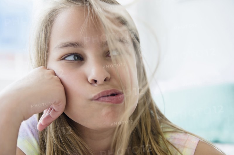 Caucasian girl blowing hair from her face