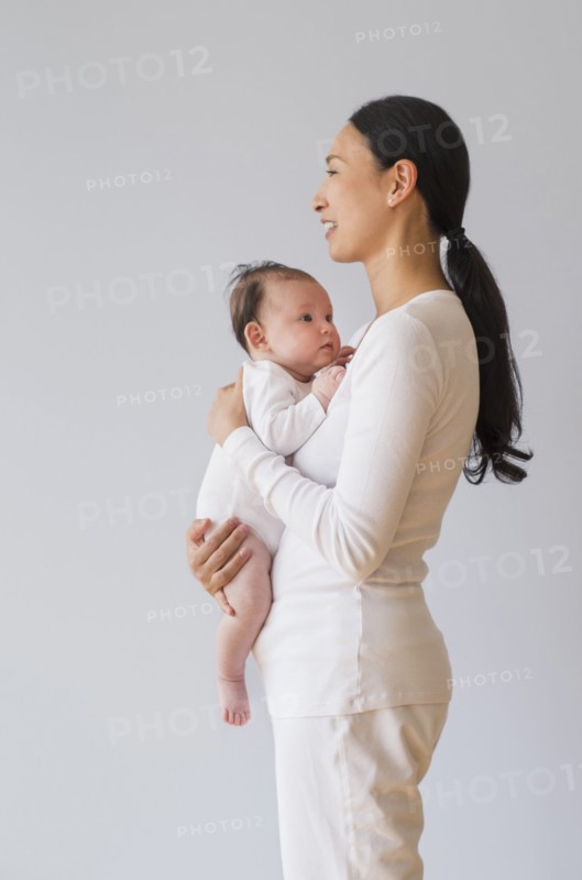 Profile of Asian mother holding baby
