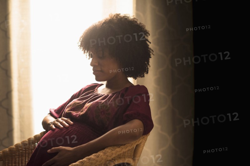 Pregnant African American mother holding her stomach
