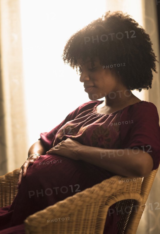 Pregnant African American mother holding her stomach