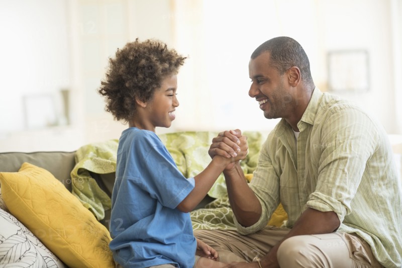 Father and son arm wrestling in living room