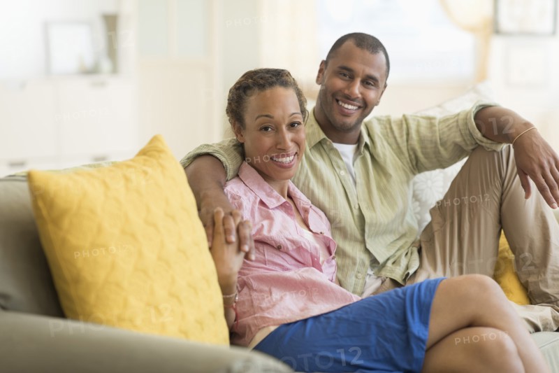 Couple smiling on sofa in living room