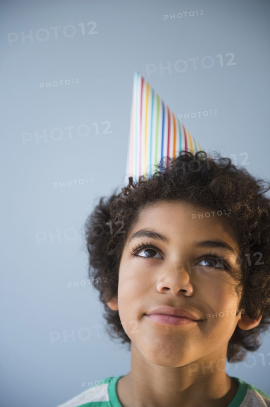 Mixed race boy wearing party hat