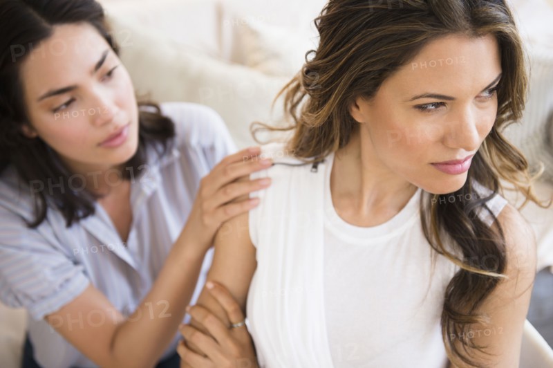 Hispanic woman comforting angry friend