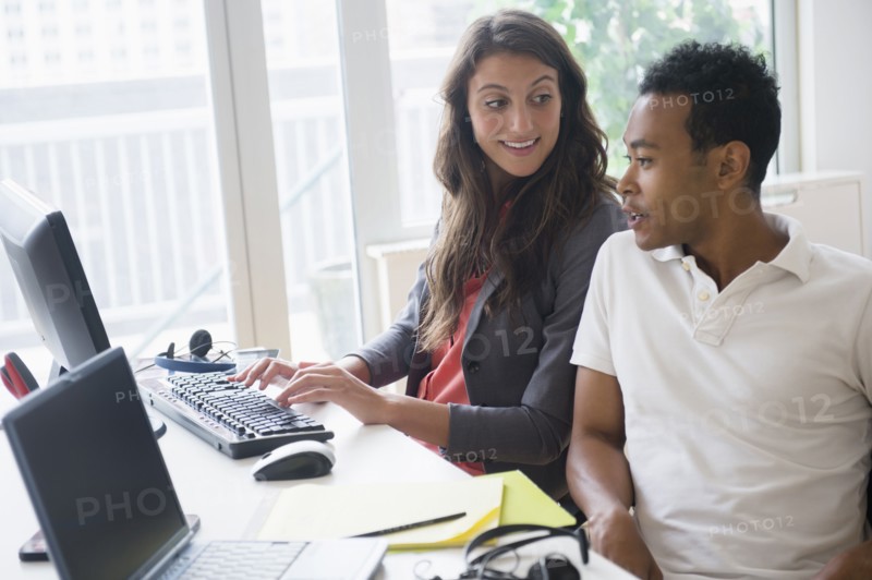 Business people working together on computer in office