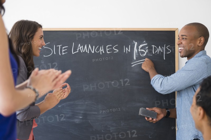 Business people cheering and gearing up for site launch in office