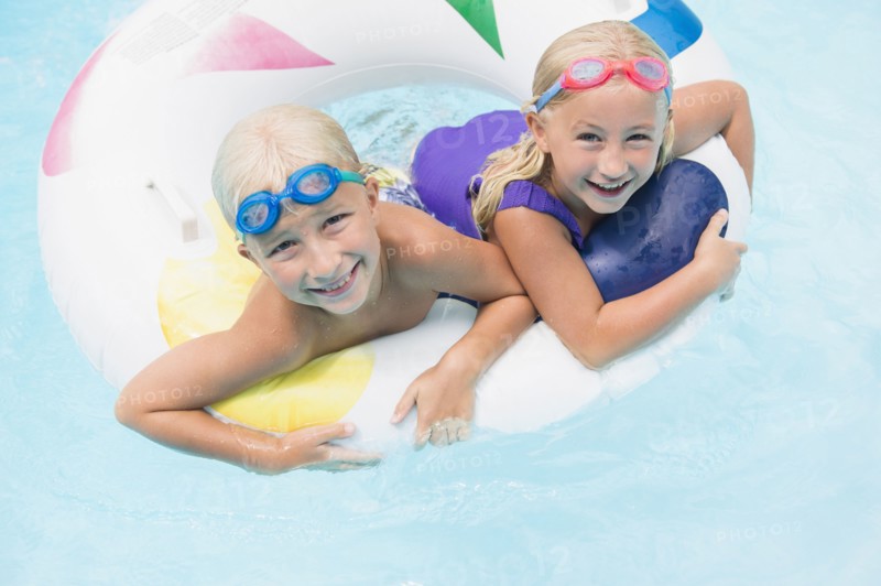 Caucasian children playing in swimming pool