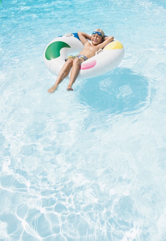 Caucasian boy floating in inflatable ring in swimming pool