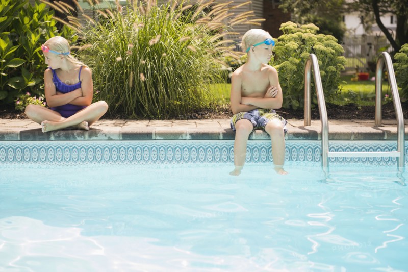 Caucasian children arguing at swimming pool