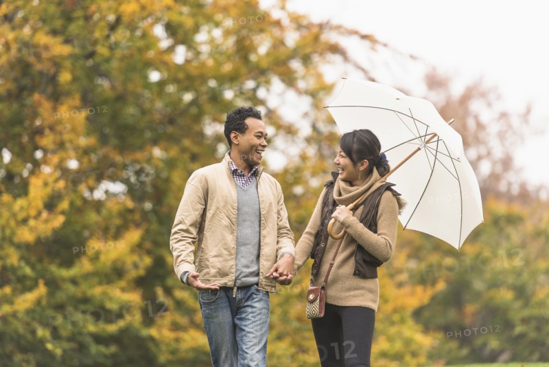 Couple walking with umbrella in park