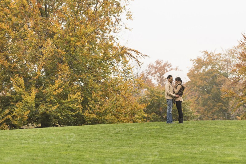 Couple standing with umbrella in park
