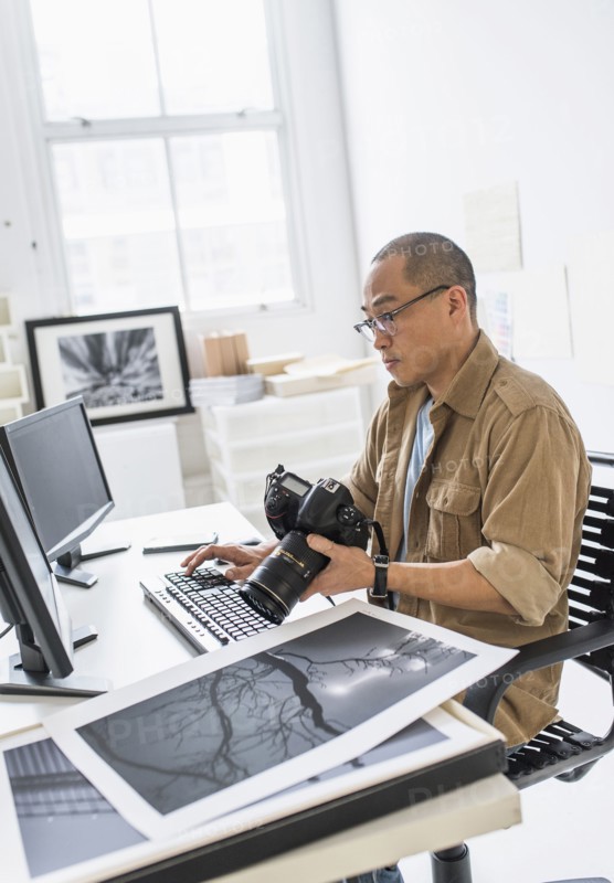 Korean photographer using computer at desk