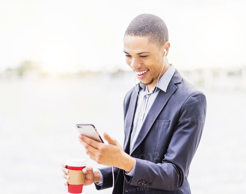 Black businessman using cell phone outdoors