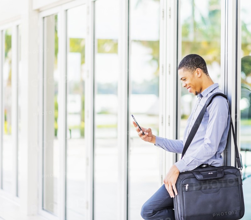 Black businessman using cell phone outdoors