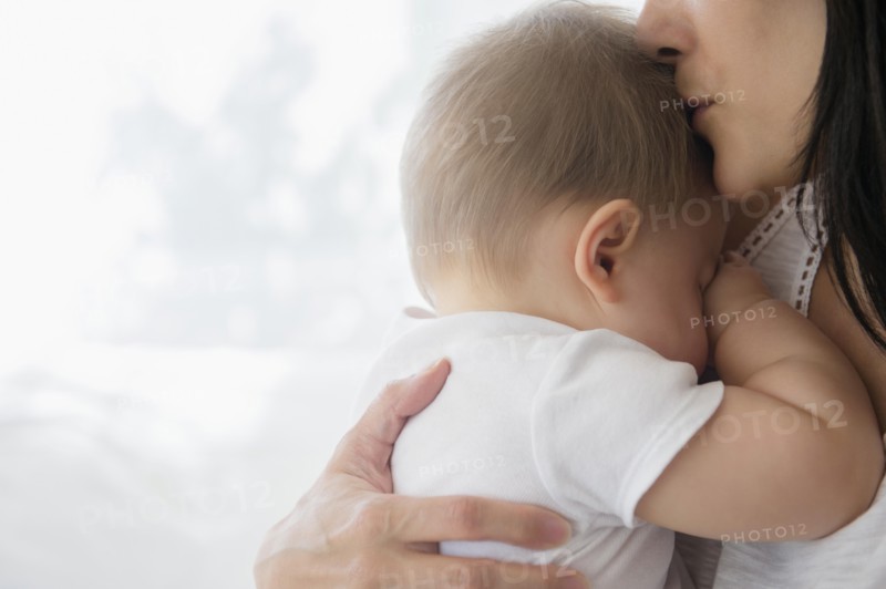 Close up of mixed race mother kissing baby on forehead