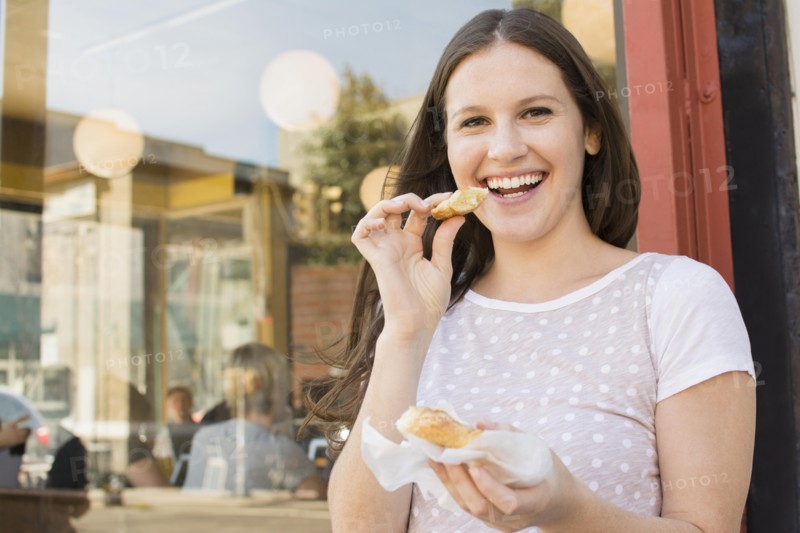 Caucasian woman eating outside cafe