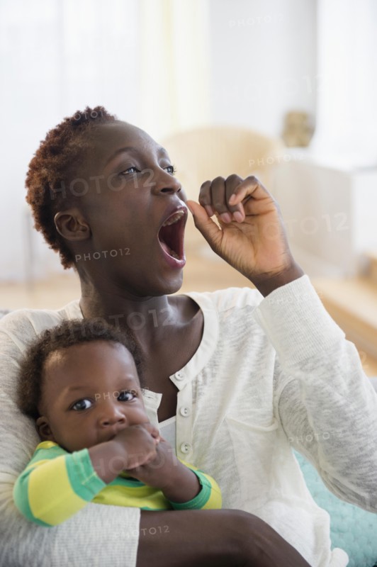 Yawning Black mother holding baby boy
