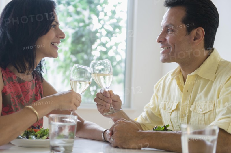 Couple toasting each other with white wine in restaurant