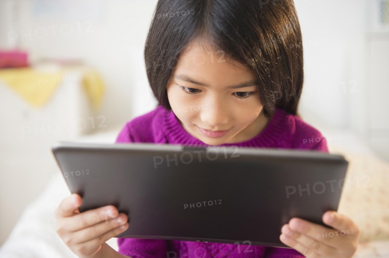 Smiling Vietnamese girl using digital tablet