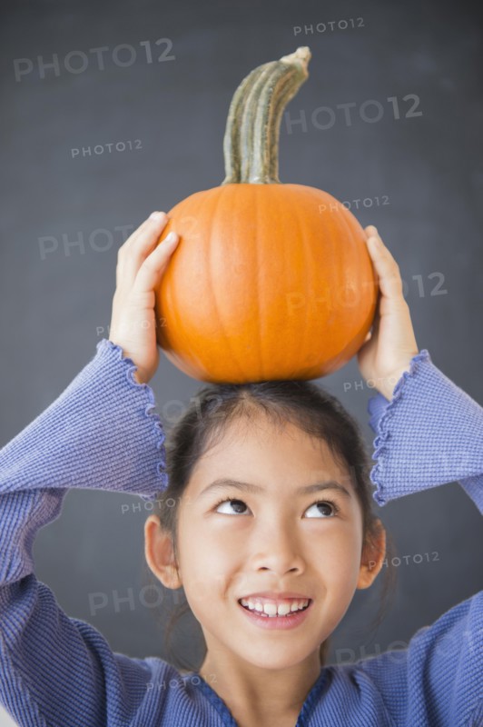 Vietnamese girl balancing pumpkin on head